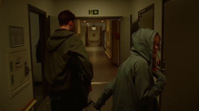 a couple of people walking down a hallway