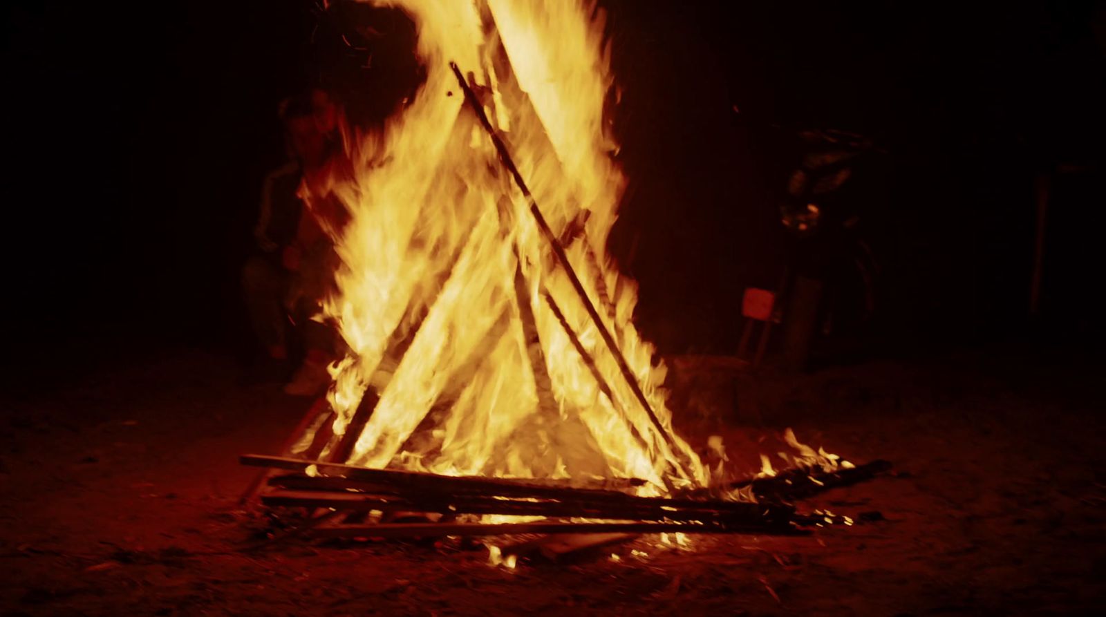 a campfire is lit in the dark with bright yellow flames