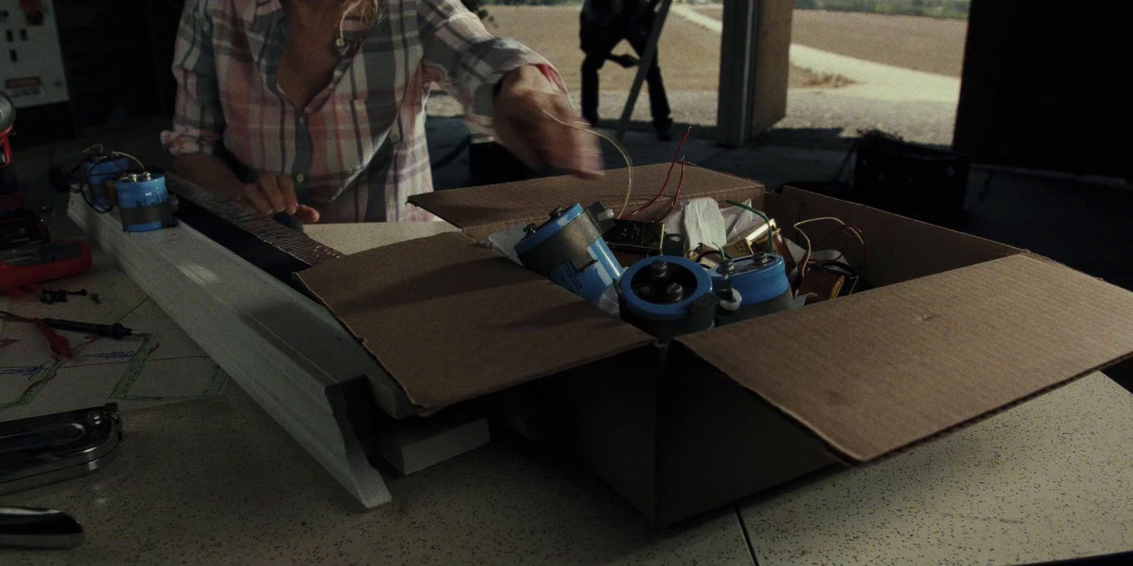 a man standing in front of a box filled with electronics