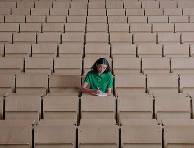 a woman sitting in a row of empty seats