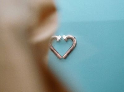 a heart shaped piece of wire sitting on top of a blue surface