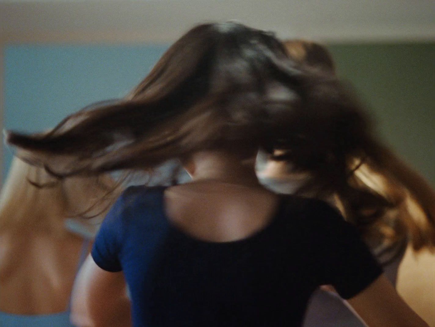 a woman is blow drying her long hair