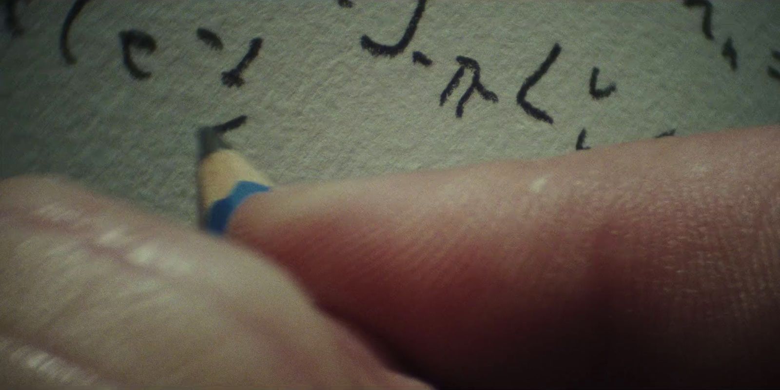 a close up of a person's hand holding a pencil