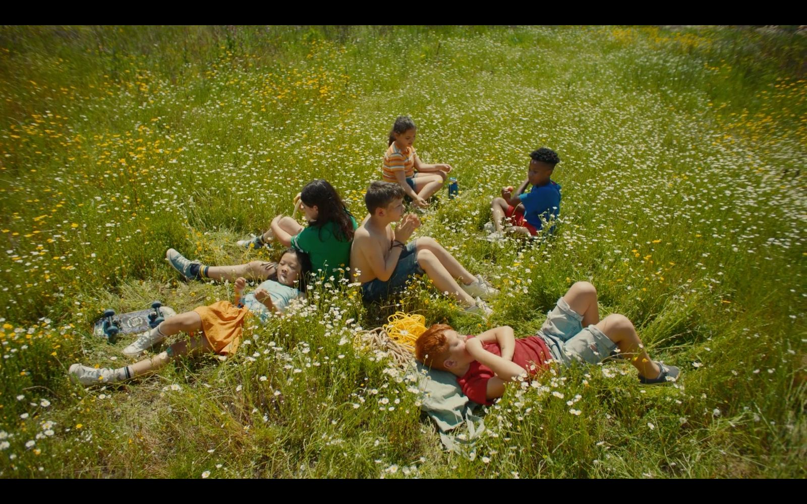 a group of people sitting in a field of grass