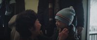 a woman is putting a hat on a child's head