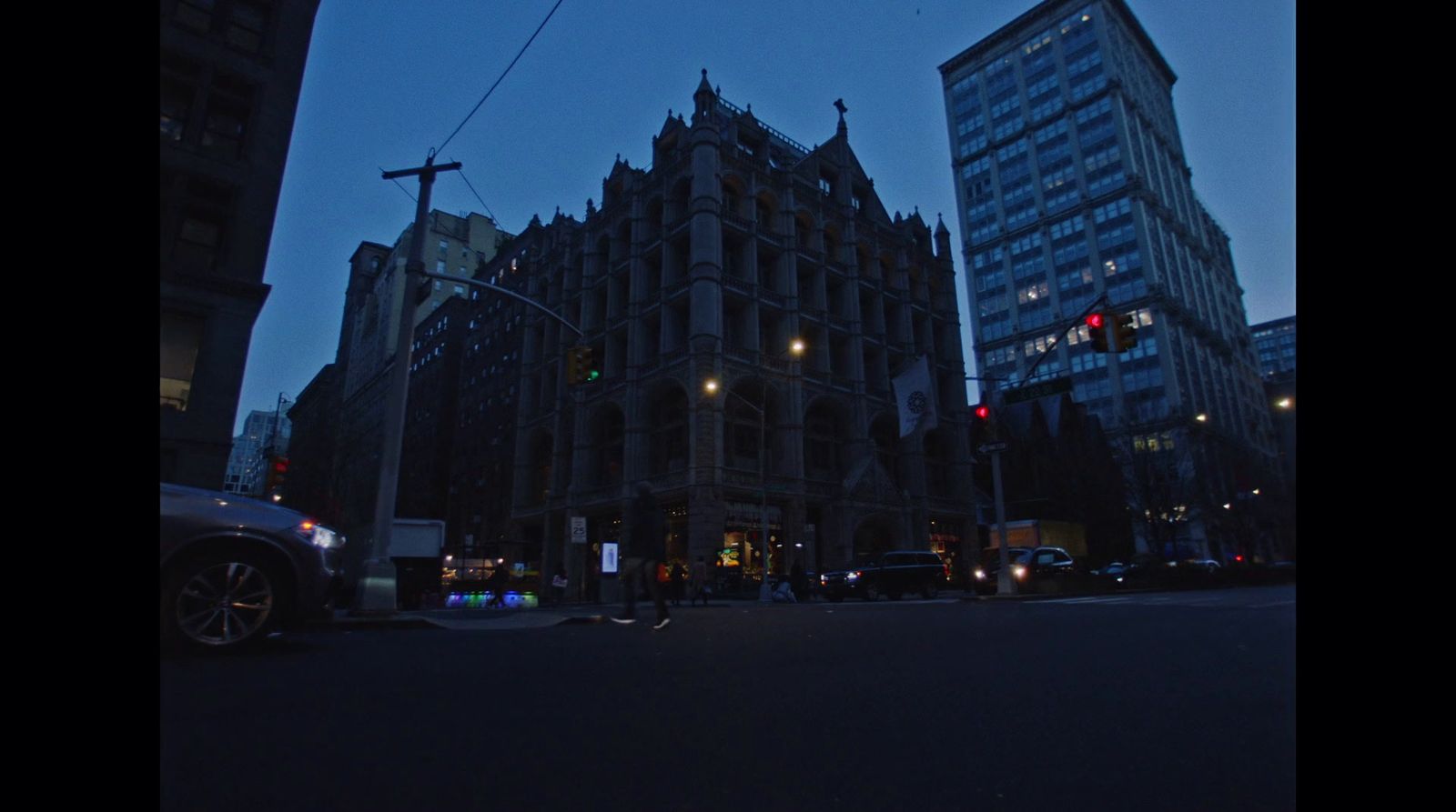 a city street at night with tall buildings