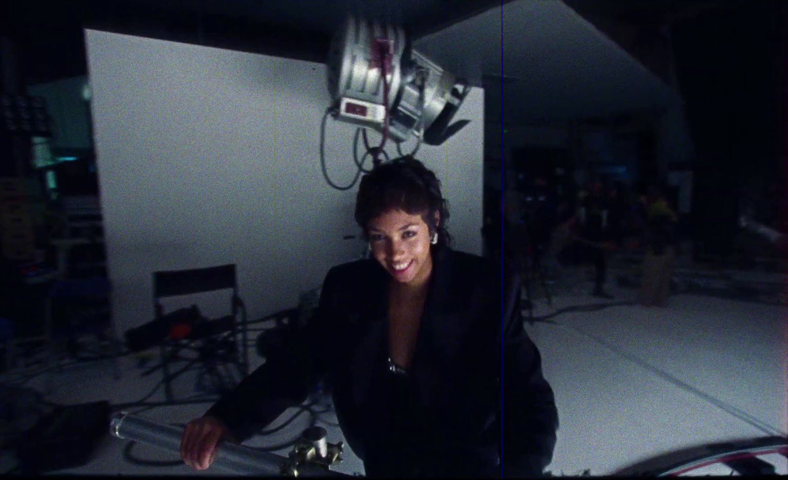 a woman sitting in a room with a camera on top of her head