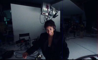 a woman sitting in a room with a camera on top of her head