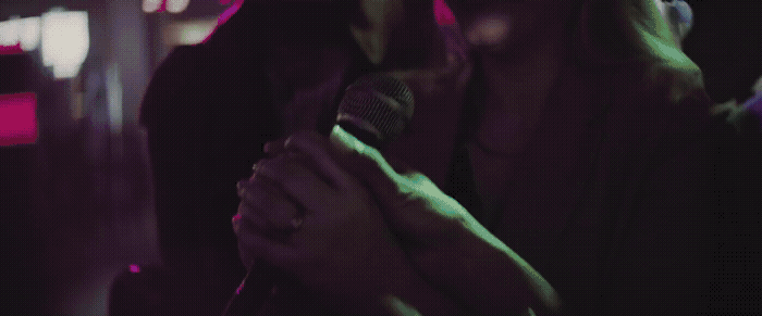 a woman holding a microphone in a dark room