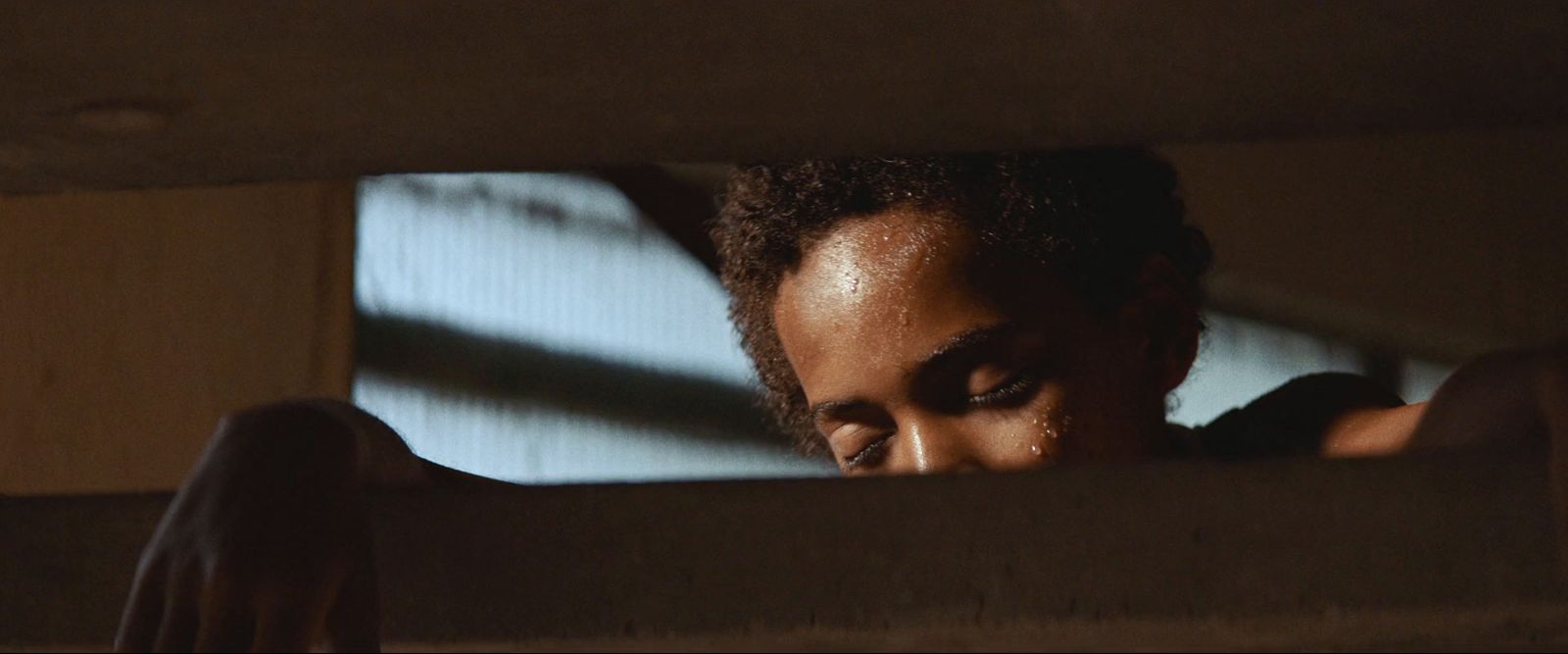 a woman looking out of a window in a dark room