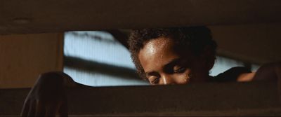 a woman looking out of a window in a dark room