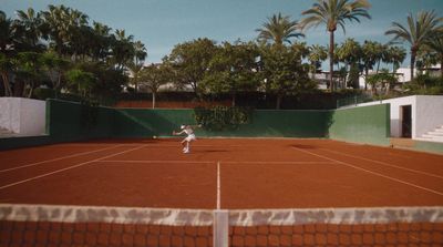 a man standing on a tennis court holding a racquet