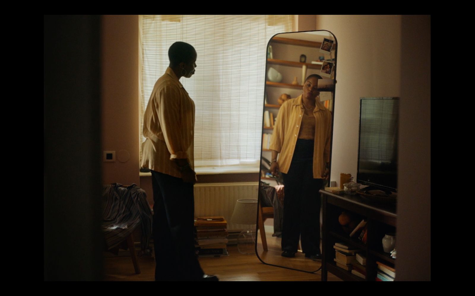 a man standing in front of a mirror in a living room