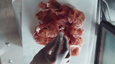 a person holding a bunch of meat in their hand