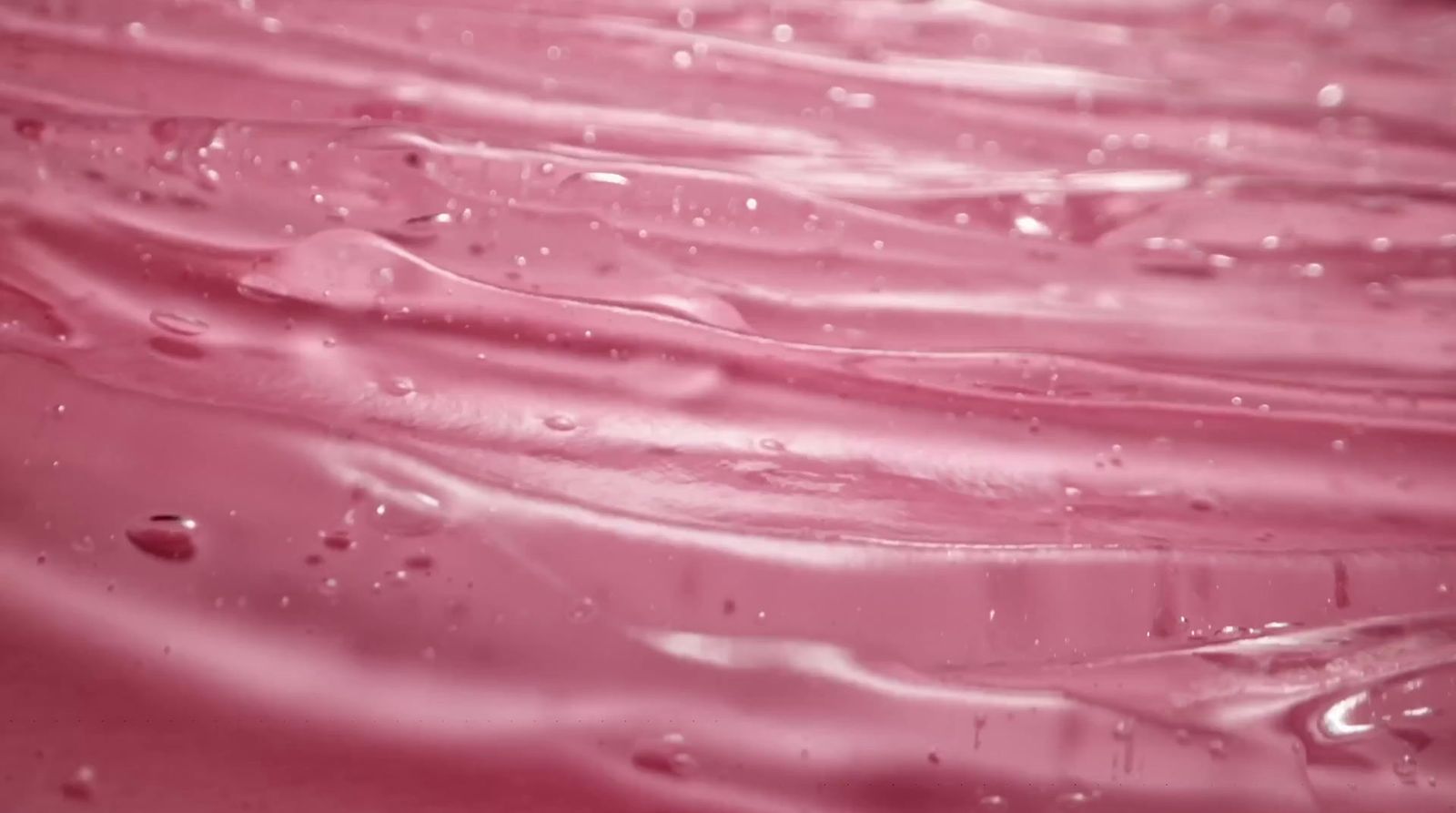 a close up of a pink liquid filled with water