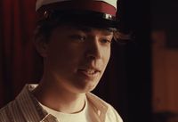 a young man wearing a sailor's hat in a room