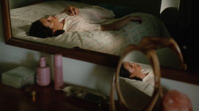 a woman laying on a bed in front of a mirror