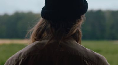 a person with a hat on standing in a field