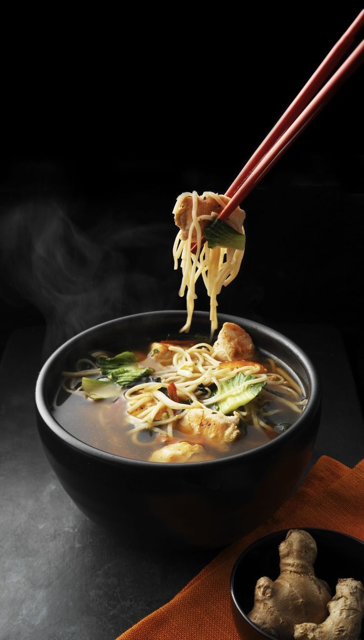 a bowl of soup with chopsticks sticking out of it