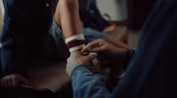 a person sitting on the ground with a cigarette in their hand