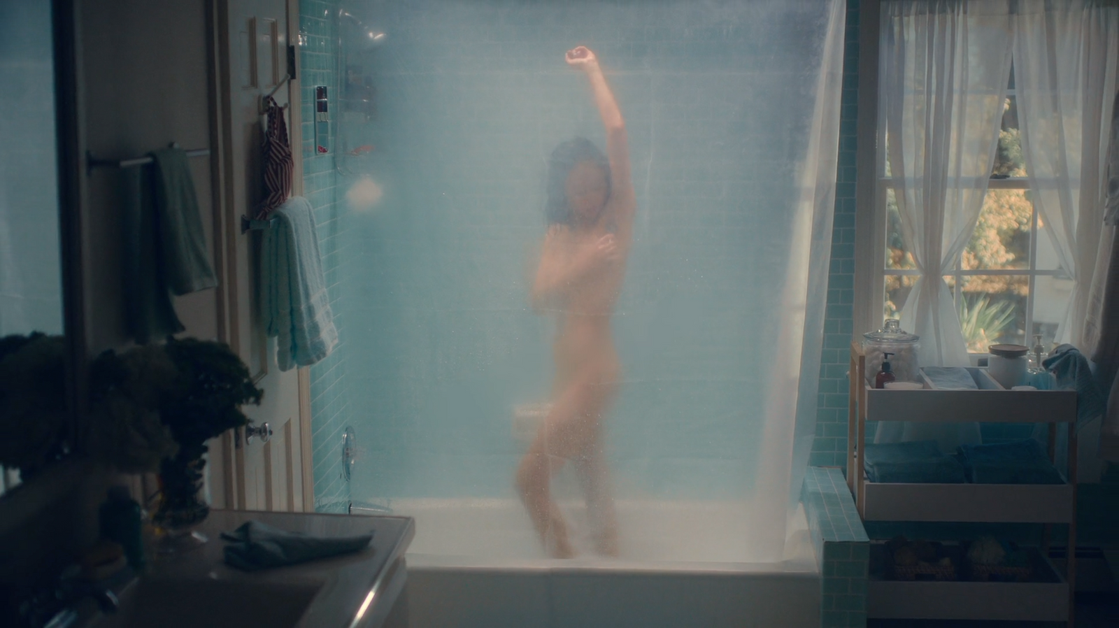 a naked woman standing in a bathtub in a bathroom