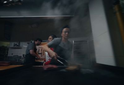 a group of people cooking in a kitchen