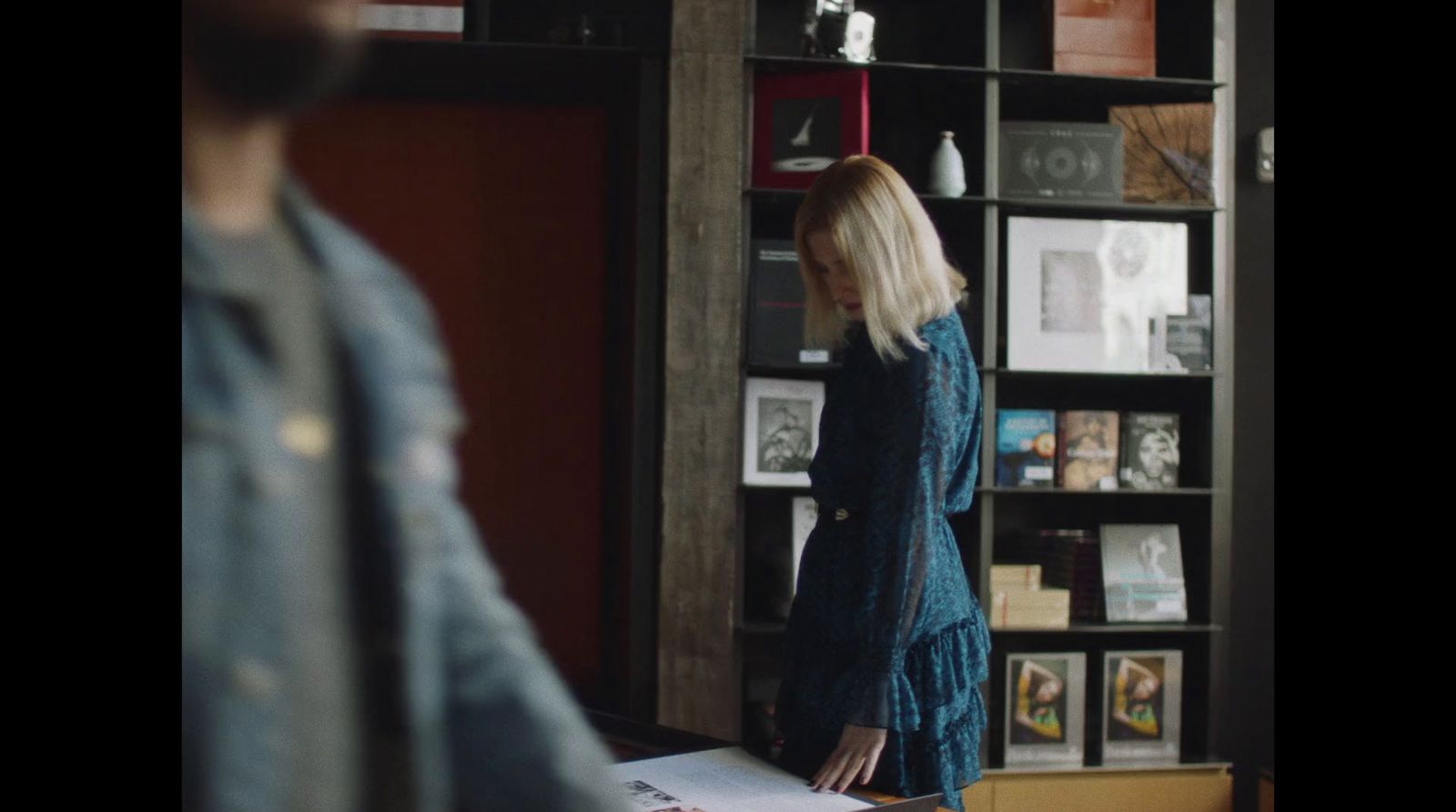 a woman standing in front of a book shelf