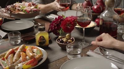 a group of people sitting at a table with plates of food