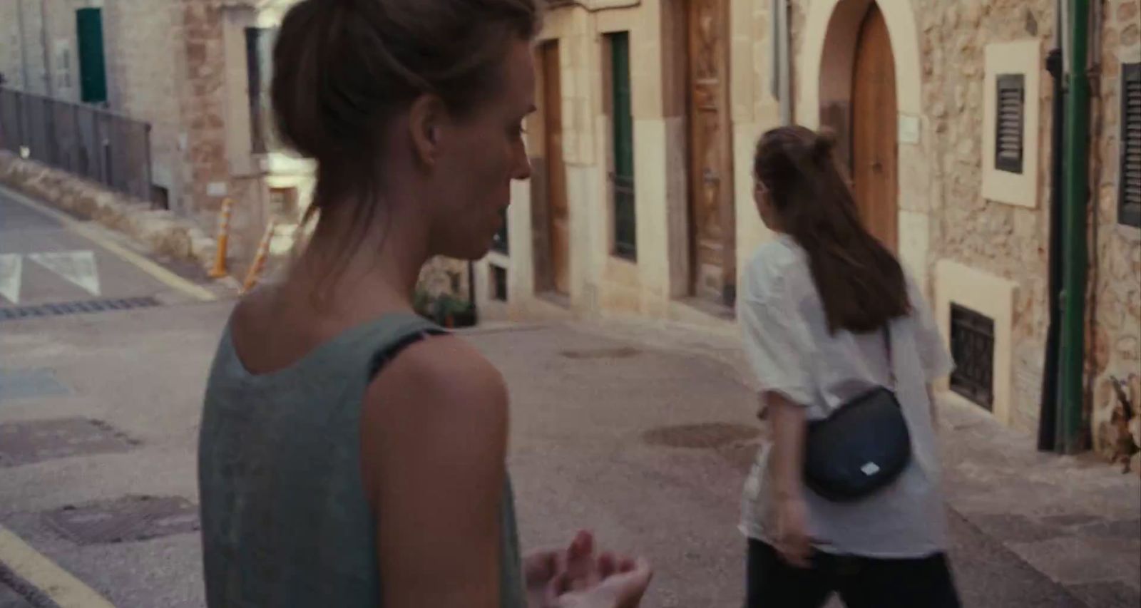 a woman walking down a street next to another woman