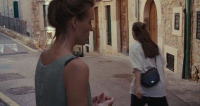a woman walking down a street next to another woman