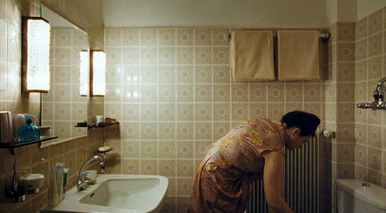 a woman in a bath room with a sink and a radiator