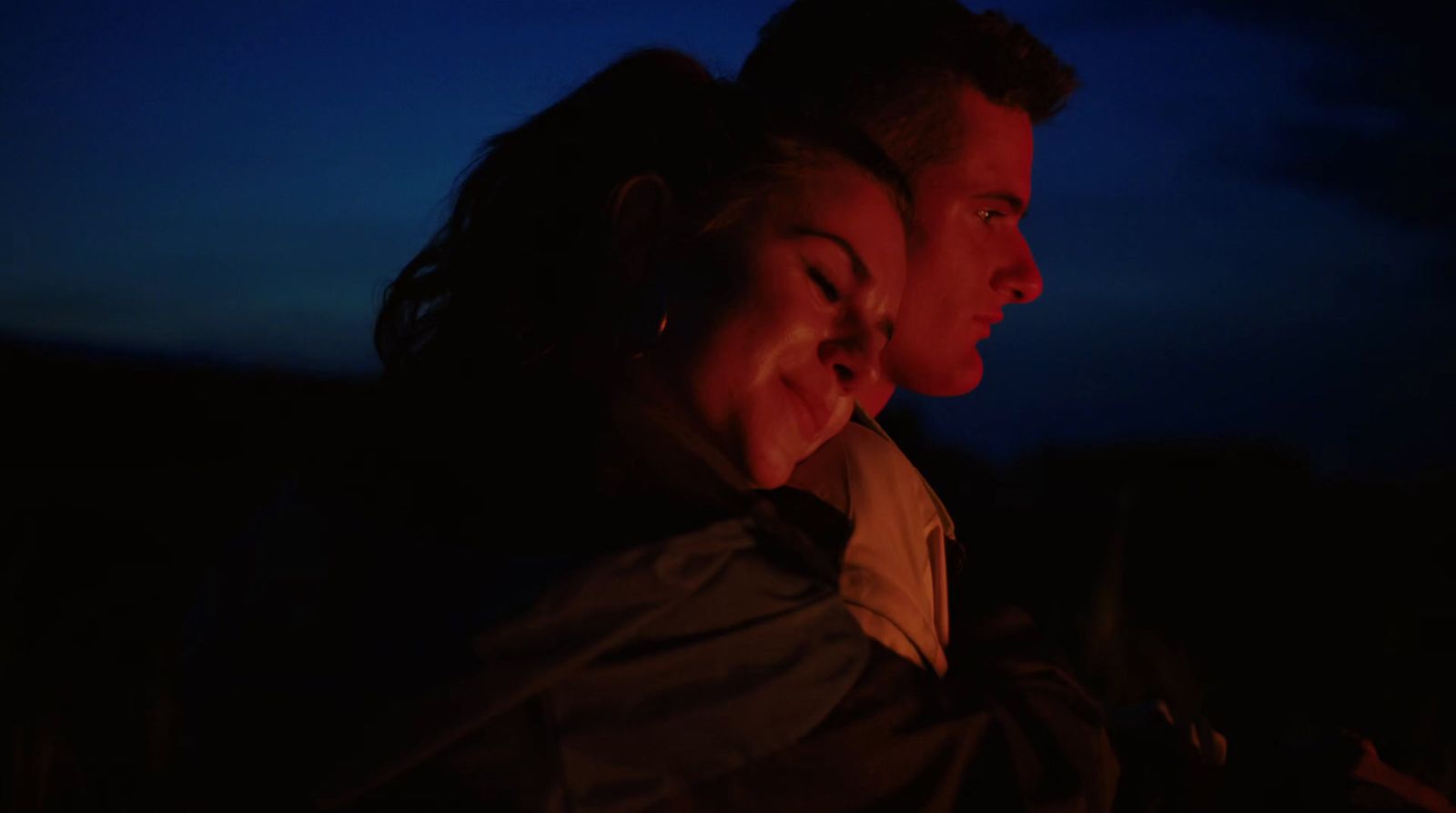 a man and a woman sitting next to each other in the dark