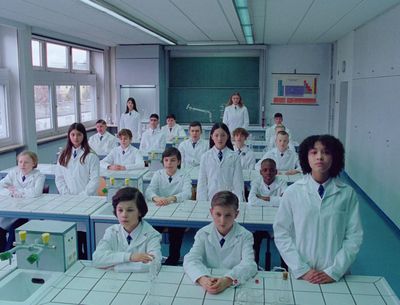 a group of students in lab coats sitting at desks