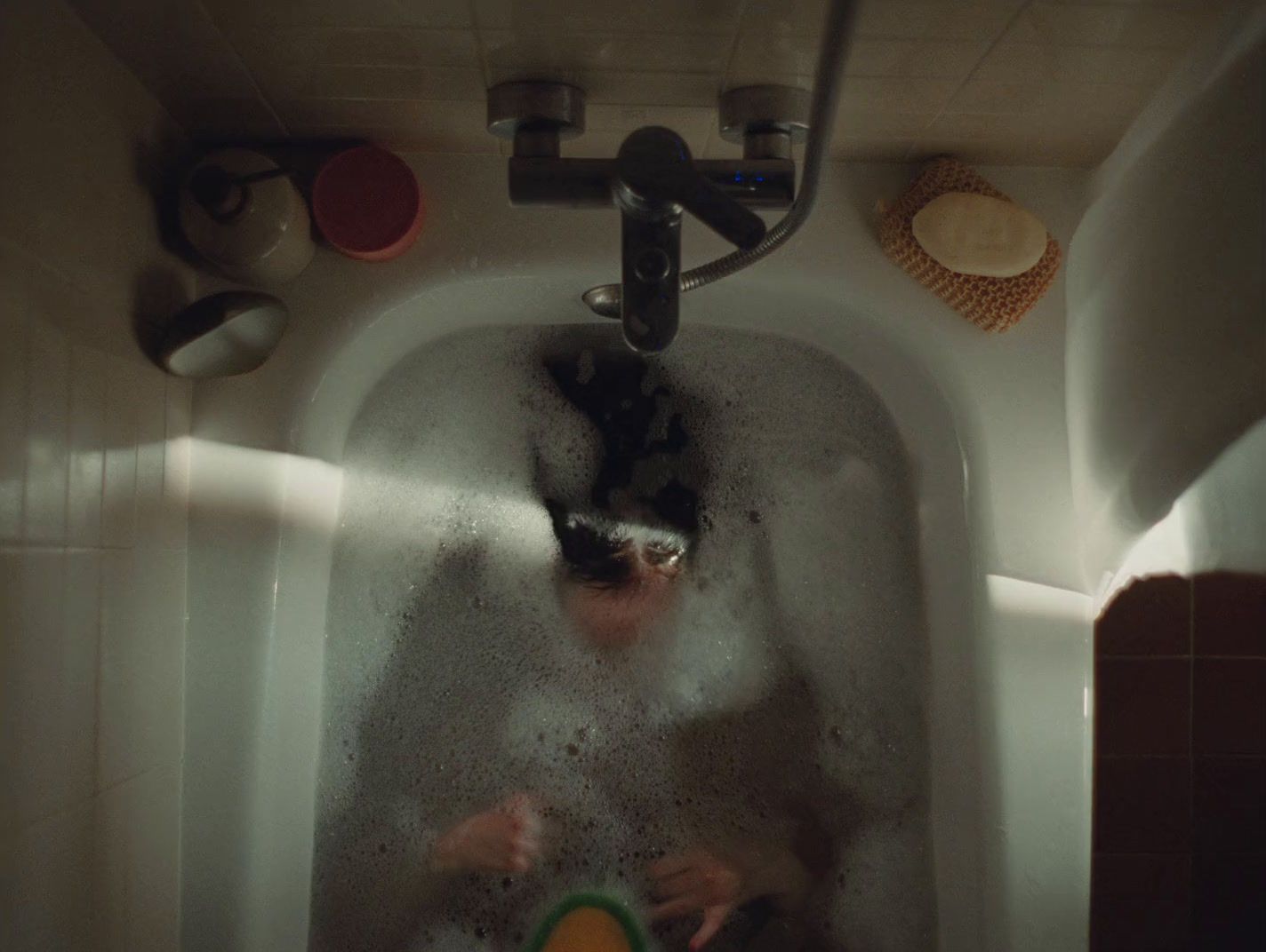 a person in a bathtub with a green bowl