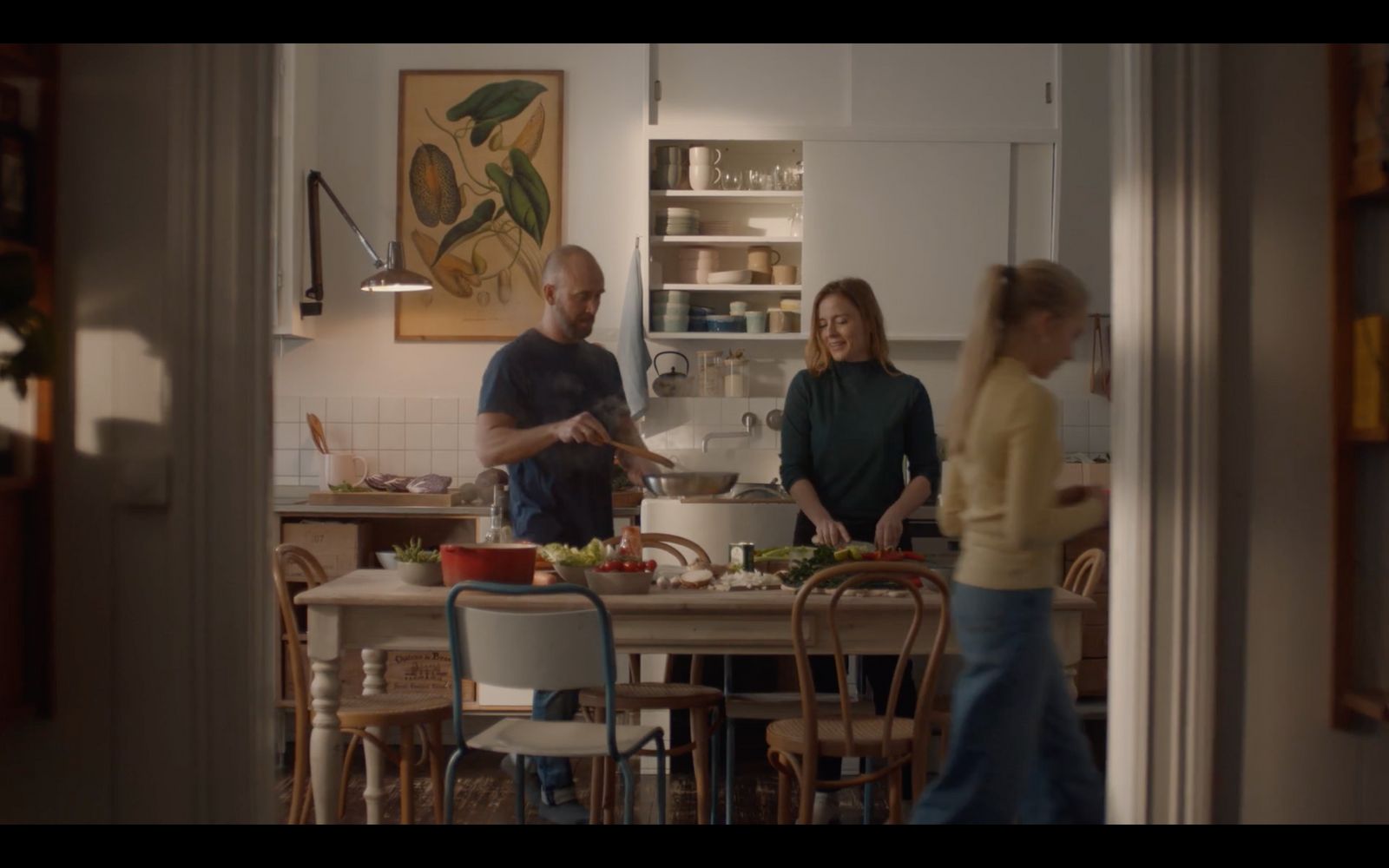 a group of people standing around a kitchen table