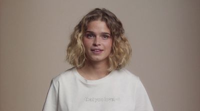 a woman with blonde hair wearing a white t - shirt