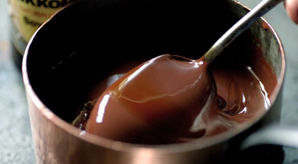 a spoon in a cup filled with chocolate