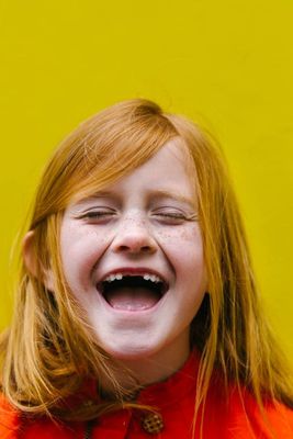 a little girl laughing with her eyes closed