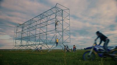 a man riding a bike next to a tall structure