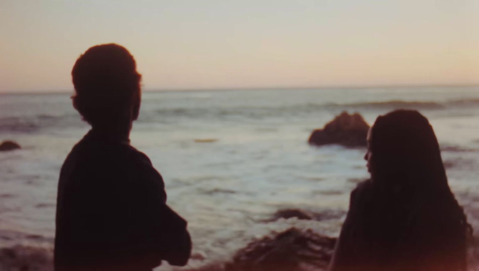 a couple of people standing on top of a beach