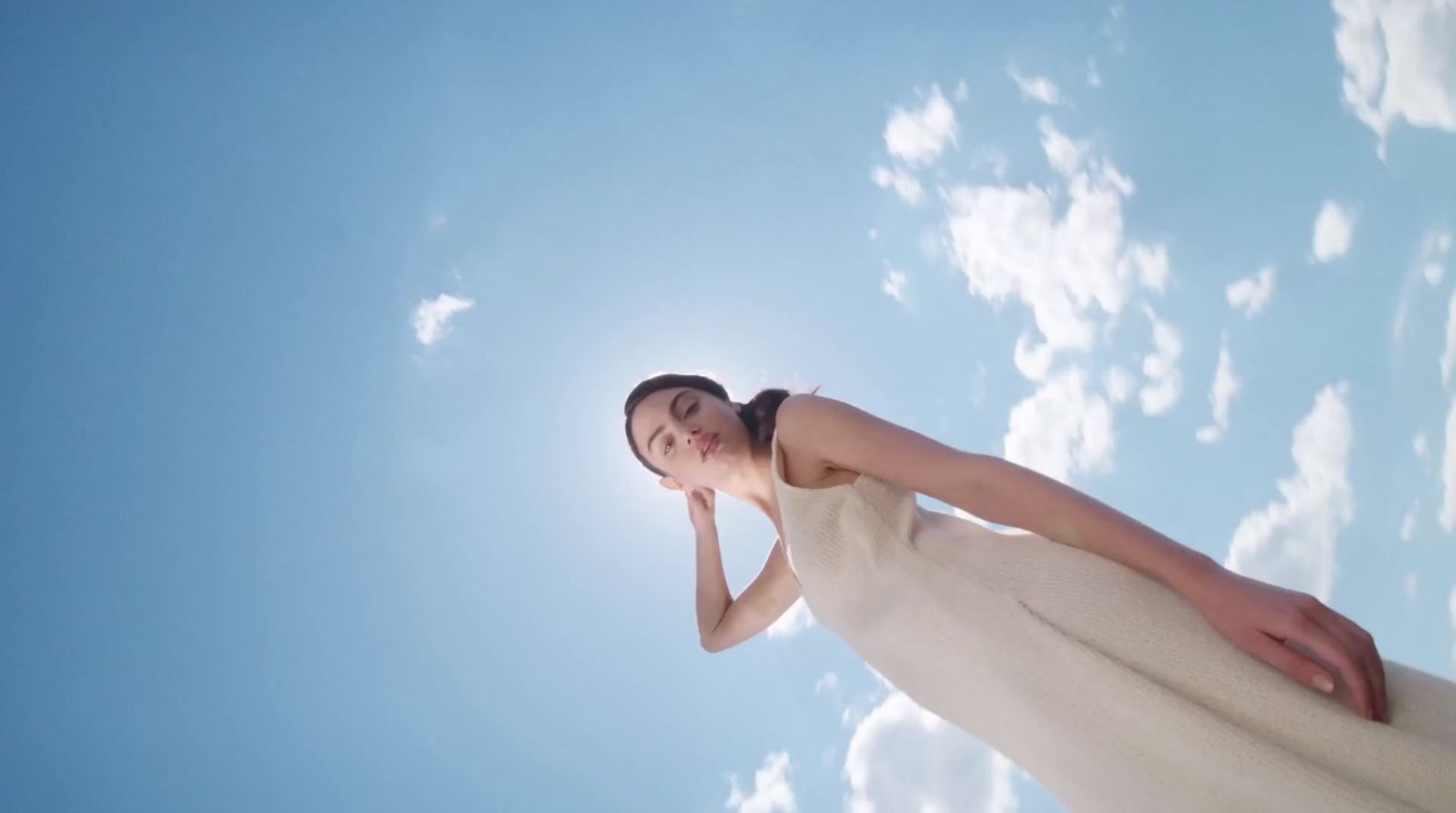 a woman in a white dress looking up into the sky