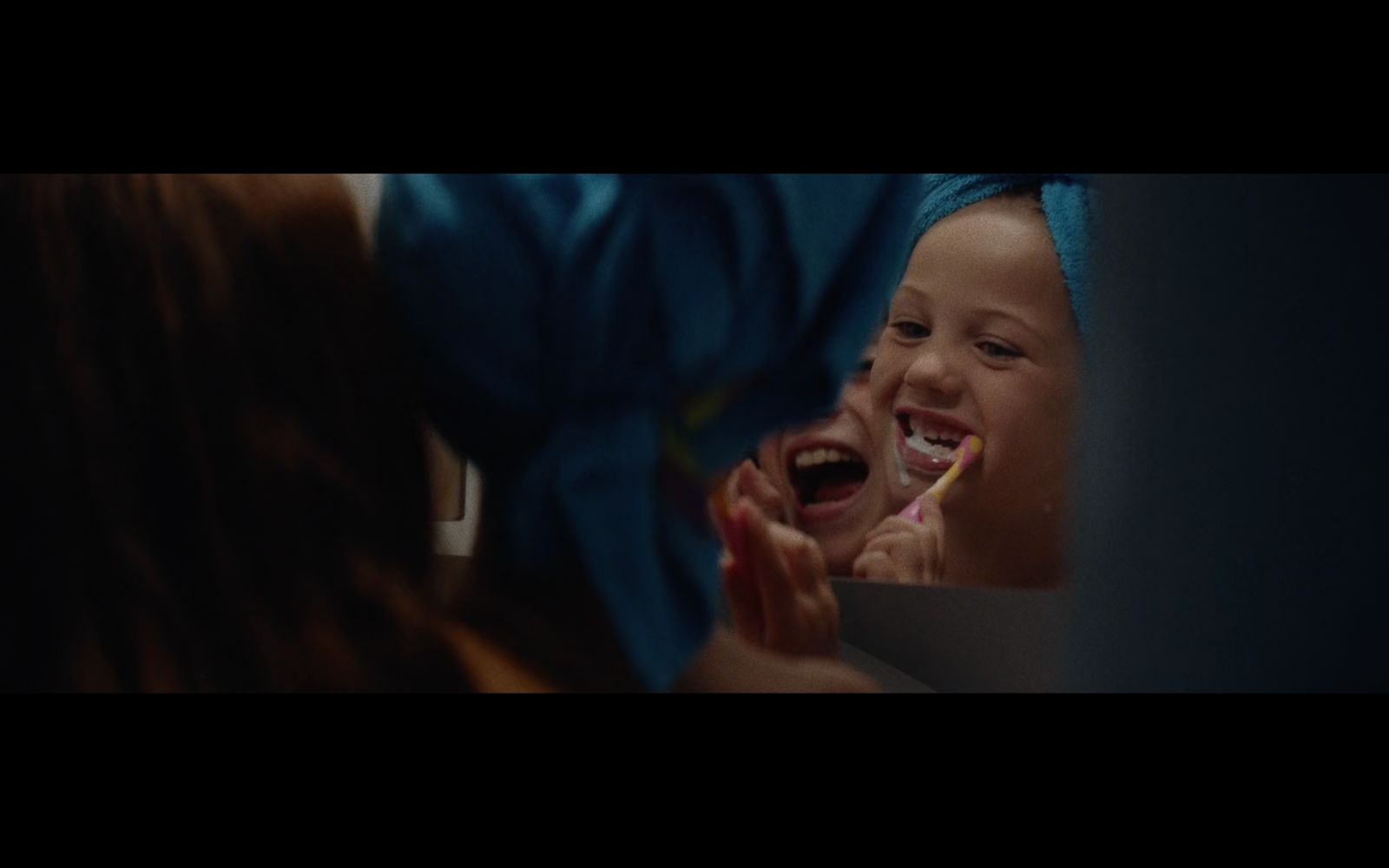 a little girl brushing her teeth with a toothbrush