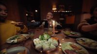 a group of people sitting around a table eating food