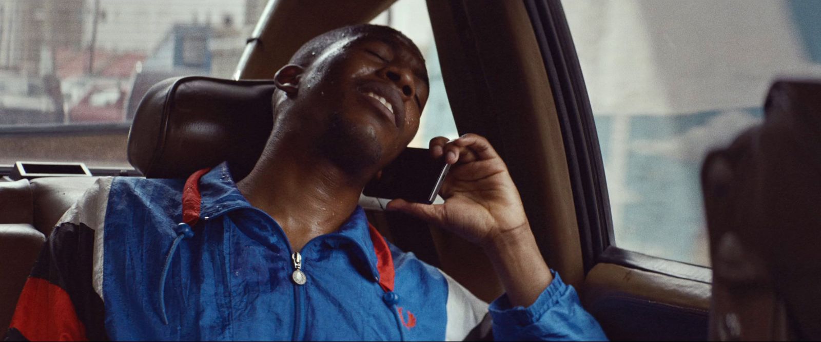 a man sitting in a car talking on a cell phone