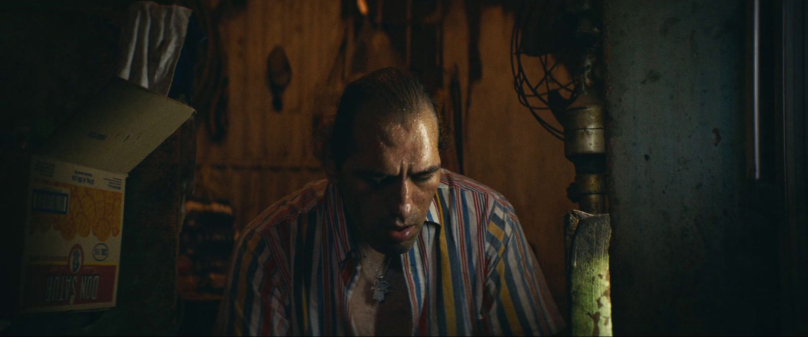 a man in a striped shirt smoking a cigarette