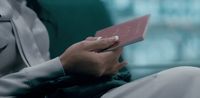 a woman is holding a passport in her hand