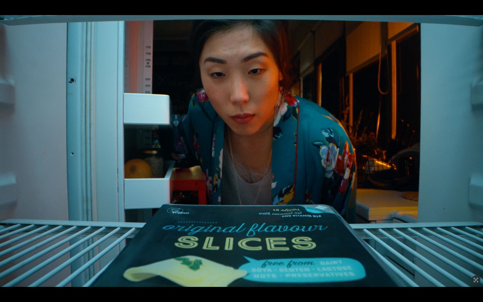 a woman looking at a book in a refrigerator