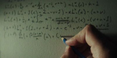 a person writing on a piece of paper with a pencil