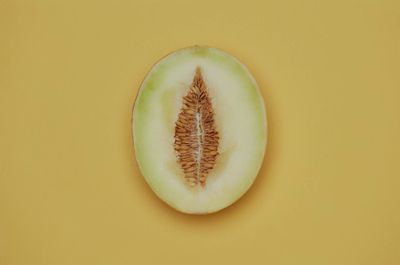 a half eaten melon on a yellow background