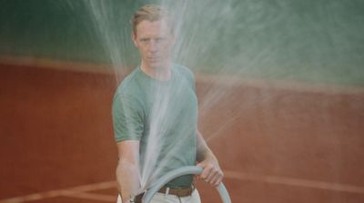 a man holding a tennis racquet on top of a tennis court